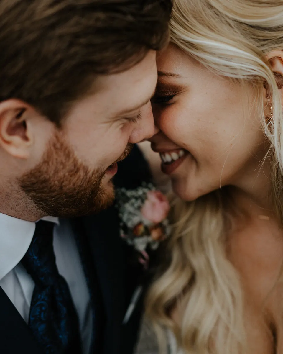 A bride and groom touching foreheads in a quiet moment